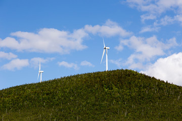 Two wind turbines on Mount Miller seen against blue sky during a beautiful sunny day, Murdochville,...