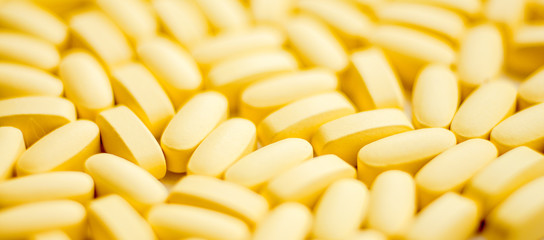 Yellow capsules pills big heap