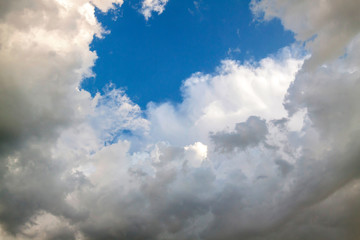 Cumulus clouds gather before the rain against a clear blue sky. Natural landscape.