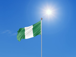 3D illustration. Colored waving flag of Nigeria on sunny blue sky background.