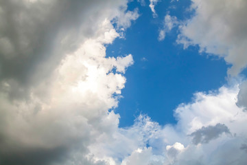 Cumulus clouds gather before the rain against a clear blue sky. Natural landscape.