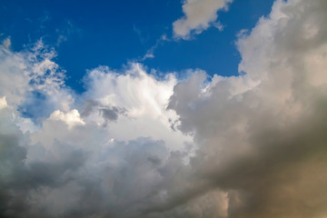 Cumulus clouds gather before the rain against a clear blue sky. Natural landscape.
