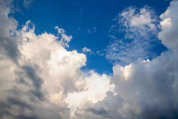 Cumulus clouds gather before the rain against a clear blue sky. Natural landscape.