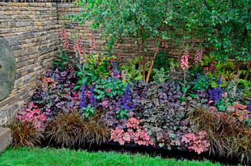 The planted border with mixed ground covering planting including Heuchera and Salvia in a country...