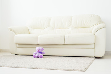 Childhood and babyhood concept - Teddy bear seated on beige carpet at bedroom