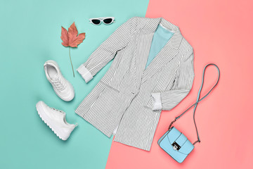 Fall fashion Clothes Accessories Outfit, Maple Leaf. Autumn creative minimal Flat lay on pink. Trendy jacket, Stylish hipster sneakers shoes, handbag, Fashionable autumnal color, shopping concept