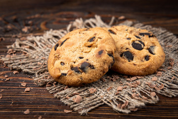 Cookies with chocolate on dark wooden background.