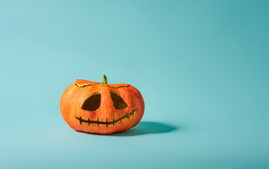 Pumpkin lantern on turquoise background.