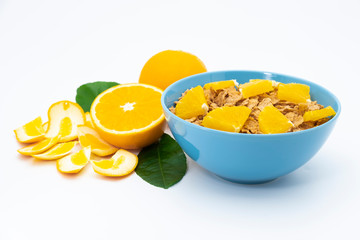 Cereal flake with pieces orange fruits slice in the blue bowl isolated on white background