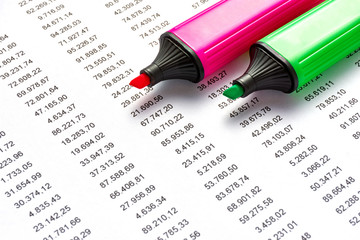 Red and geen marker on a white sheet of paper with printed financial numerical data table money numbers. Concept for accounting, budget, profit, tax and financial review.  