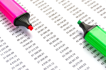 Red and geen marker on a white sheet of paper with printed financial numerical data table money numbers. Concept for accounting, budget, profit, tax and financial review.  
