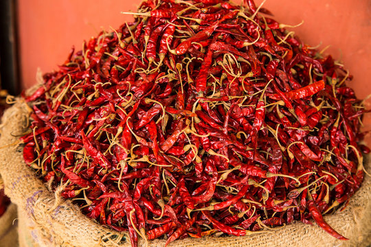 Dried red chilly kept in a gunny sack outside a shop in a spice market. background - image