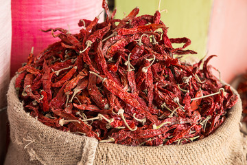 Dried red chilly kept in a gunny sack outside a shop in a spice market. background - image