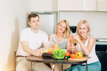 Friends sitting at table in kitchen