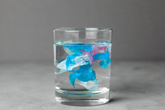 Microplastic. Water pollution by small particles of plastic. Glass of water with plastic