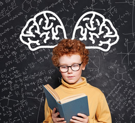 Smart child student wearing glasses holding book and learning science