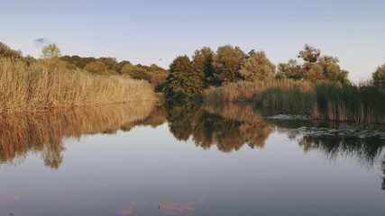 Aerial shot with drone flying close to the water in canyon during sunny day