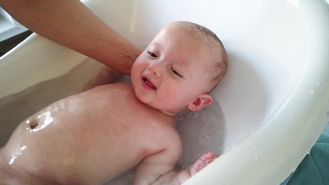 Mother take a bath for his newborn baby. Baby bath time