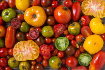 Close up of colorful tomatoes, some sliced, shot from above