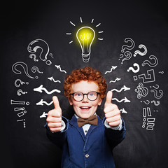 Happy smart child boy in blue suit and  lightbulb