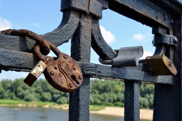 Old rusty love locks or padlocks attached to a bridge or fence. Symbol of unbreakable love and lifetime commitment. Lover's locks