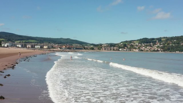 Minehead beach in Somerset with people playing in the sea