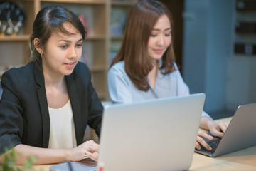Two Female university students working in the library.