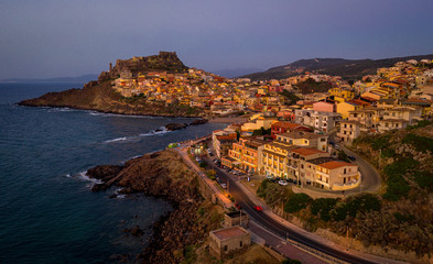 Night panorama of colorful houses on the hillsides with a fortress on the top. Aerial view of medieval town of Castelsardo