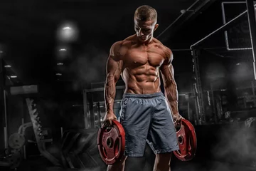 Papier Peint photo autocollant Fitness Bodybuilder de jeune athlète masculin posant et faisant des exercices de sports dans le gymnase