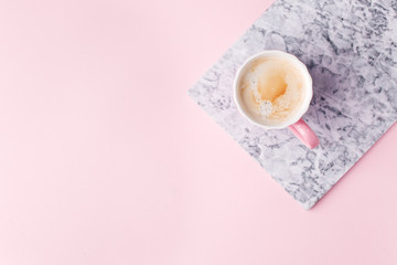 Creative flat lay concept top view of coffee cup on marble plate on pastel pink background and copy space, minimal style, saint valentine romance trendy composition