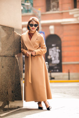 Asian girl in a stylish trench coat on the street