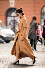 Obraz premium Asian girl in a stylish trench coat on the street