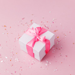 White gift box and confetti on pink background with copy space for text. fashion and shopping concept. wedding, marriage or birthday composition. flat lay, top view