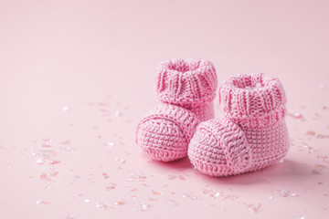 Pair of small baby socks on pink background with copy space for your warm message, baby shower,...