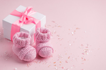 Fototapeta Pair of small baby socks and gift box on pink background with copy space for your warm message, baby shower, first newborn party background, copy space obraz