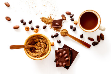 Different variety of chocolate and hazelnut on white background top view
