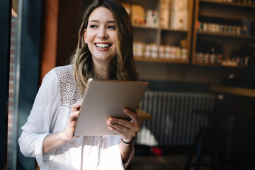 Beautiful brunette woman using laptop in cafe