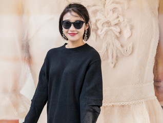 Asian girl in black sweater wearing sunglasses on the street