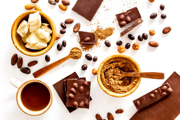Chocolate with nuts and its ingredients on white background top view