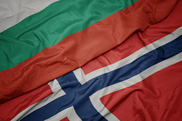 waving colorful flag of norway and national flag of bulgaria.