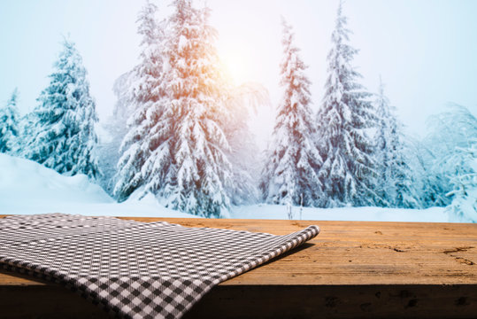 Empty wood flooring on blurred winter background. Empty space for Your object. Backdrop, table layout with winter landscape and snowflakes.