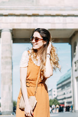  walk around Berlin with a blogger. smiling girl traveler at the Brandenburg gate.