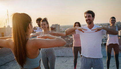 Fitness, sport, friendship and healthy lifestyle concept . Group of happy people exercising