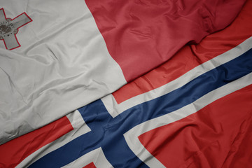 waving colorful flag of norway and national flag of malta.
