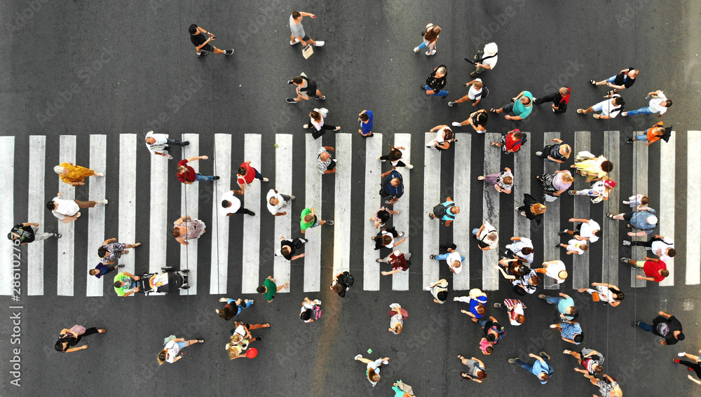 Wall mural aerial. people crowd. many people going through the pedestrian crosswalk. top view.