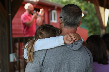 A father holds his daughter during a church service.