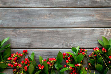 Fototapeta na wymiar Background for blog with green plant and berries frame on wooden background top view space for text
