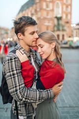 Fototapeta premium Young loving couple hugs at central square in Krakow (Cracow).