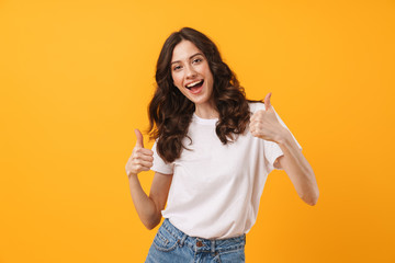 Image of gorgeous brunette woman wearing casual clothes smiling and showing thumbs up at camera - obrazy, fototapety, plakaty