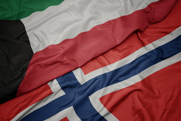 waving colorful flag of norway and national flag of kuwait.